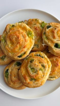 some broccoli and cheese muffins on a white plate