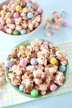 two bowls filled with candy popcorn on top of a table