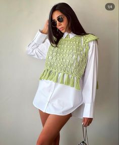 a woman in white shirt and shorts holding a handbag