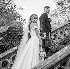 a bride and groom standing on the steps at their wedding venue in edinburgh, scotland