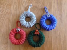 three small crocheted wreaths sitting on top of a wooden table