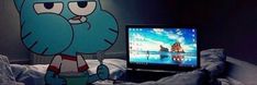 a cartoon character sitting in front of a laptop computer on a bed with the tv turned on