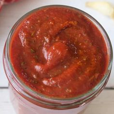 a jar filled with sauce sitting on top of a table