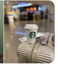 a cup of starbucks coffee sitting on top of a piece of luggage at an airport