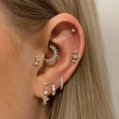 a woman's ear with three different types of piercings