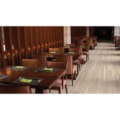 an empty restaurant with wooden tables and brown chairs, along with menus on the table