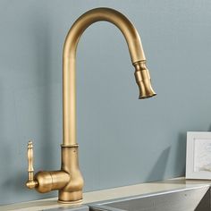 a gold faucet in a kitchen with blue walls