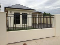 a white house with a black fence and gate