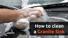 a hand holding a sponge on top of a car with the words how to clean a granite sink