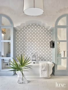 a bathroom with a bathtub, sink and potted plant