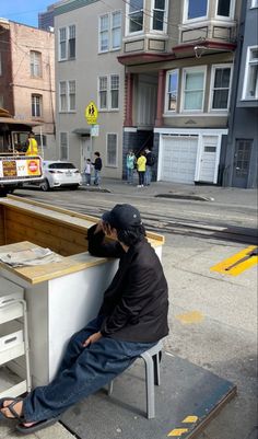 a man sitting at a desk on the sidewalk