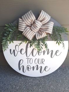 a welcome to our home sign with a bow