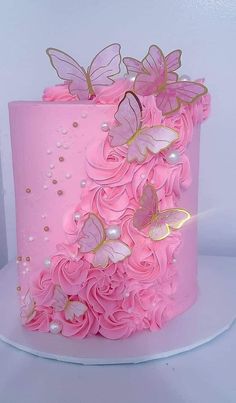 a pink cake with gold butterflies on top