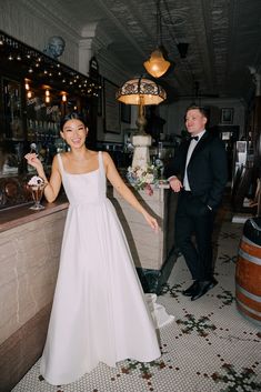 a woman in a white dress standing next to a man