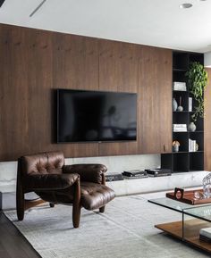 a living room with leather furniture and a flat screen tv mounted on the wall above it