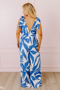 - Perfect for a sunny stroll, this fabulous jumpsuit will boost your confidence! - Material with an abstract print - A v-cut neckline and back - A sleeveless cut featuring tie closure straps - A wide banded waistline with an elastic back - Back zip closure - A built-in lining that ends above the knee - A flowy and flattering silhouette that ends in wide hemlines Capri Jumpsuit, Boost Your Confidence, V Cut, V Cuts, Above The Knee, Abstract Print, The Knee, Sunnies, Royal Blue