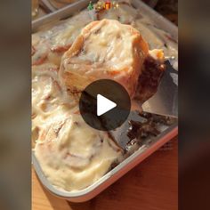 a pan filled with meat and cheese covered in gravy next to a spatula