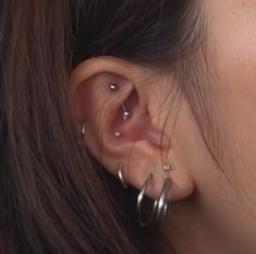 a close up of a woman's ear with two hoops attached to it