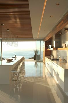 a large kitchen with an island counter top and bar stools next to the ocean