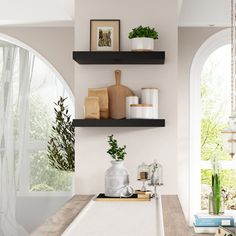 a white sink sitting under two arched windows