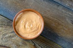 a small bowl filled with peanut butter on top of a wooden table