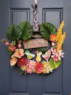 a wreath is hanging on the front door with flowers and leaves around it, which reads happy birthday