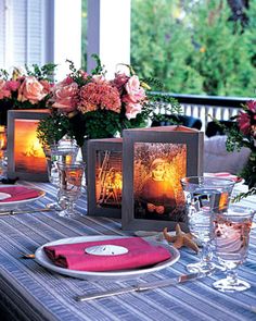 the table is set with candles, plates and flowers in vases on top of it