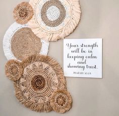 woven wall hangings with bible verse displayed on grey surface next to white and brown doily