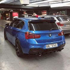 a blue bmw car parked in a parking garage