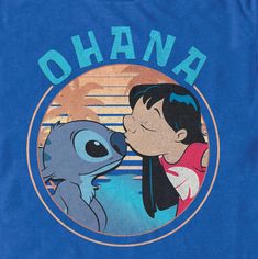 a blue shirt with an image of a cartoon character kissing the face of a baby stitcher stitched into it