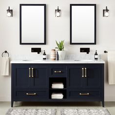 two mirrors are above the double sink vanity in this white and blue bathroom with gold handles