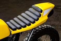 a close up of the seat on a yellow motorcycle