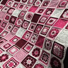 a pink and white crocheted blanket with flowers on it