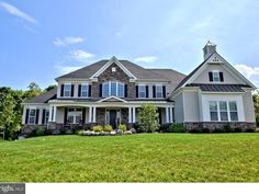 a large white house sitting on top of a lush green field