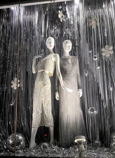 two mannequins dressed in silver dresses standing next to each other