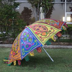 an upside down colorful umbrella sitting in the grass