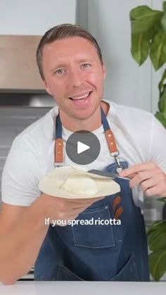 a man in an apron is holding a plate