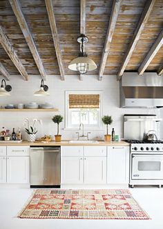 a kitchen with white cabinets and stainless steel stove top oven, dishwasher, microwave and refrigerator