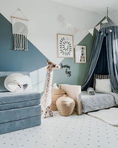 a child's bedroom decorated in shades of blue, white and grey with a giraffe stuffed animal