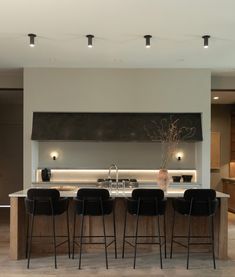 the kitchen is clean and ready to be used for dinner or breakfast time, as well as an island with four bar stools