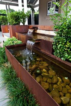 a water feature in a garden with rocks and plants