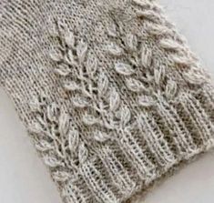 a close up of a knitted sweater with leaves on it