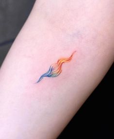 a small tattoo on the arm of a woman's left arm, with an orange and blue wave