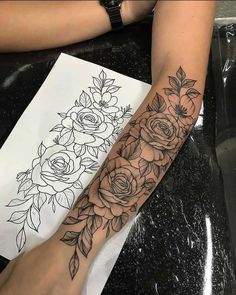 a woman's arm with flowers and leaves on it, next to a drawing