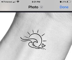 the sun and heart tattoo on someone's left arm is shown in black ink