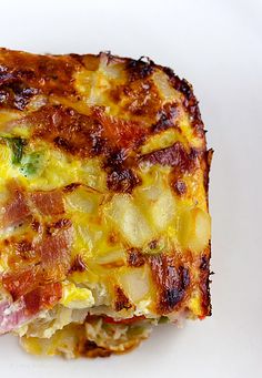 an omelet with bacon and broccoli is shown on a white plate