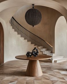 a wooden table sitting in the middle of a room next to a spiral stair case