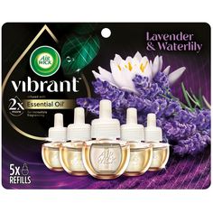 four bottles of air wick lavender and waterlily essentials on a purple background