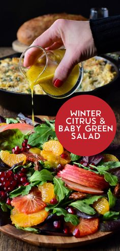 a person pouring dressing into a salad with oranges and cranberries on the side