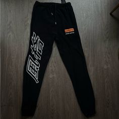 Size M Black Tapered Leg Sweatpants For Streetwear, Urban Black Tapered Leg Joggers, Black Athleisure Bottoms For Streetwear, Black Graphic Print Loungewear Pants, Black Tapered Leg Sweatpants, Graphic Print Trousers For Streetwear, Black Bottoms With Letter Print For Streetwear, Black Letter Print Bottoms For Streetwear, Urban Black Pants With Letter Print